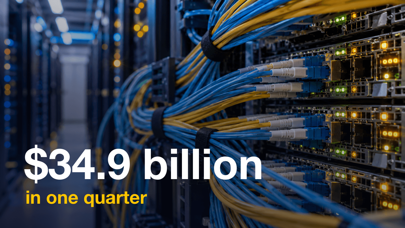 Dense bundles of blue and yellow fiber optic cables plugged into network switches inside a data center aisle