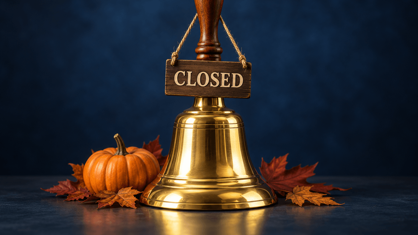 Brass trading bell with a closed sign, autumn leaves and a small pumpkin, for the stock market's Thanksgiving holiday